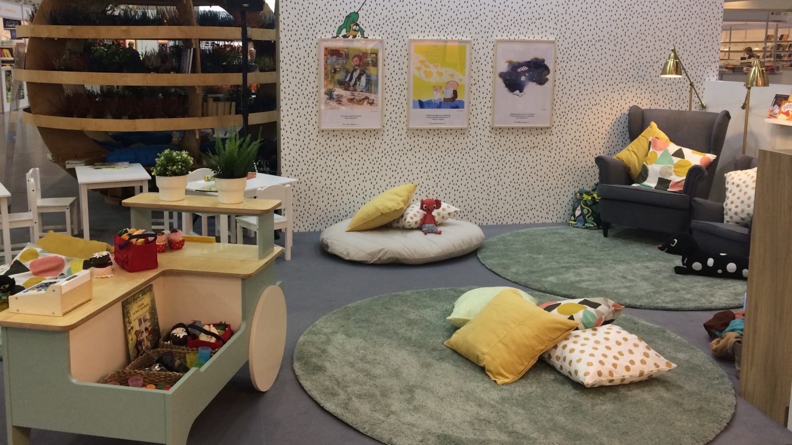 A small library and a playful space with toys and pillows.