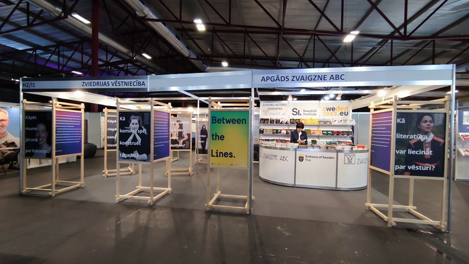 Several exhibition modules with posters at a book fair. 
