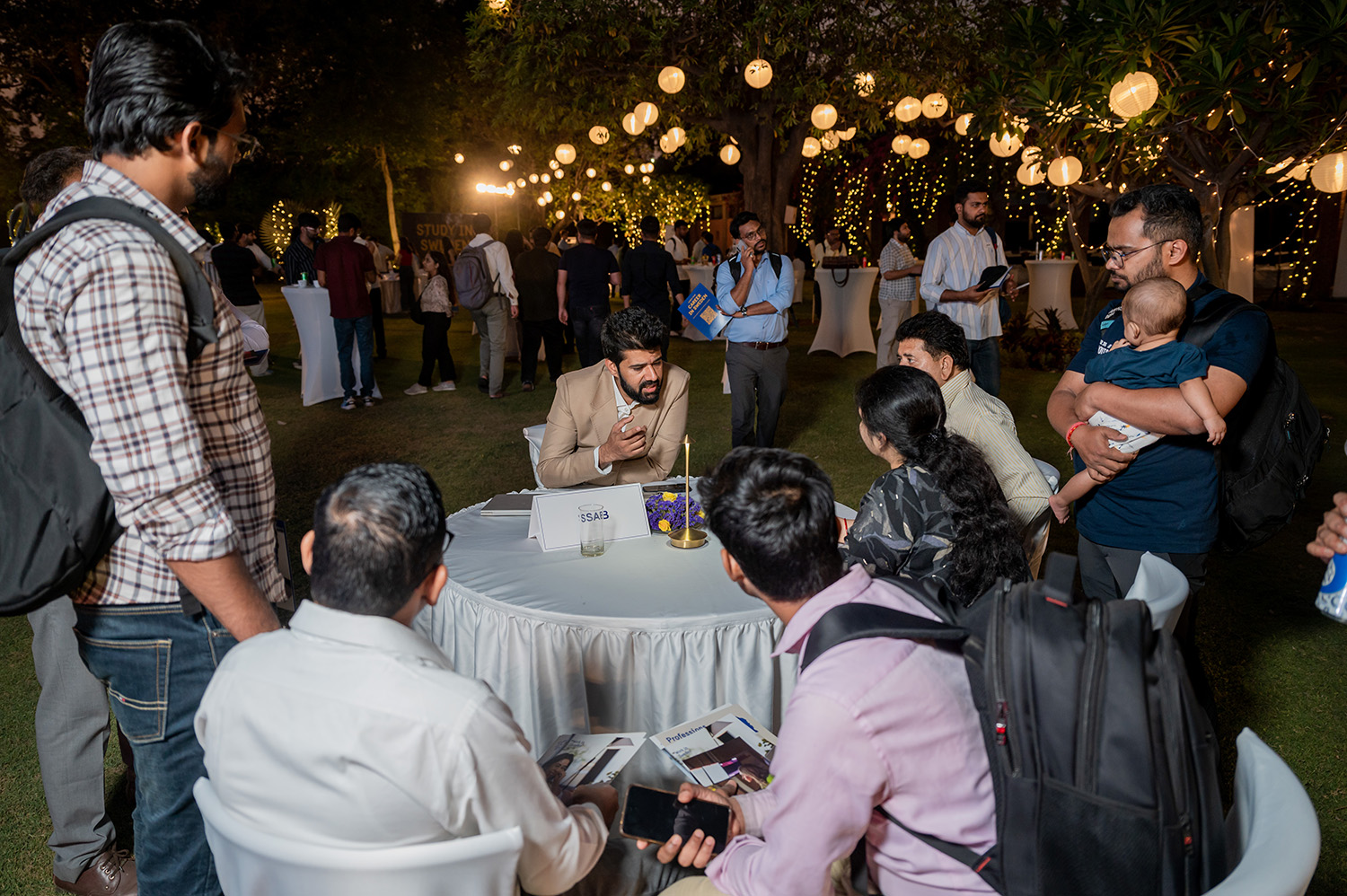 People talking at a table at the event in New Delhi.