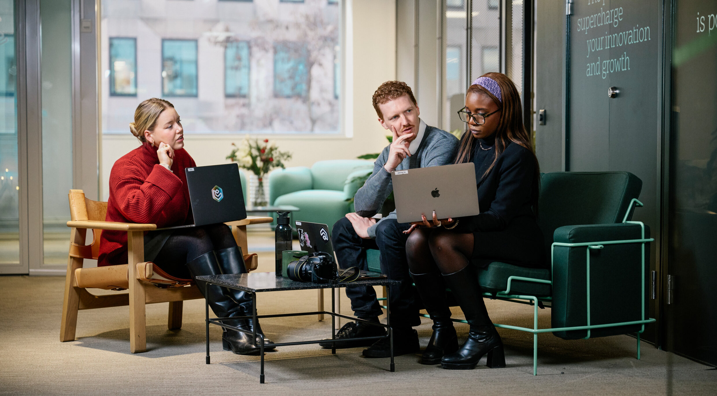 A modern office environment where employees work on laptops.