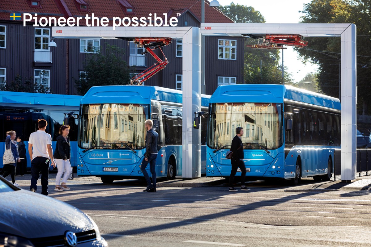 Two buses parked at an electric charging station.