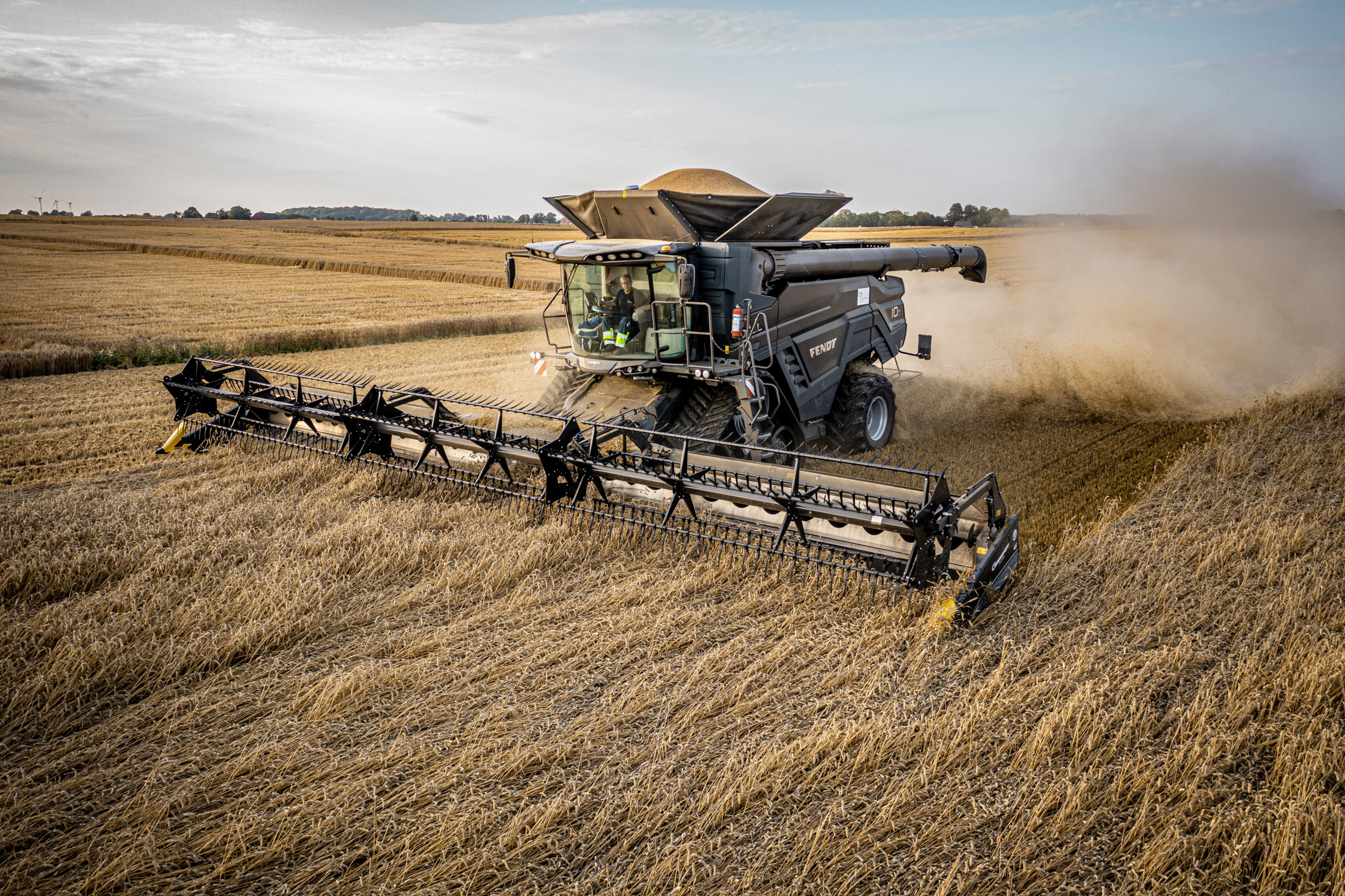 A threshing machine is in use on farmland.