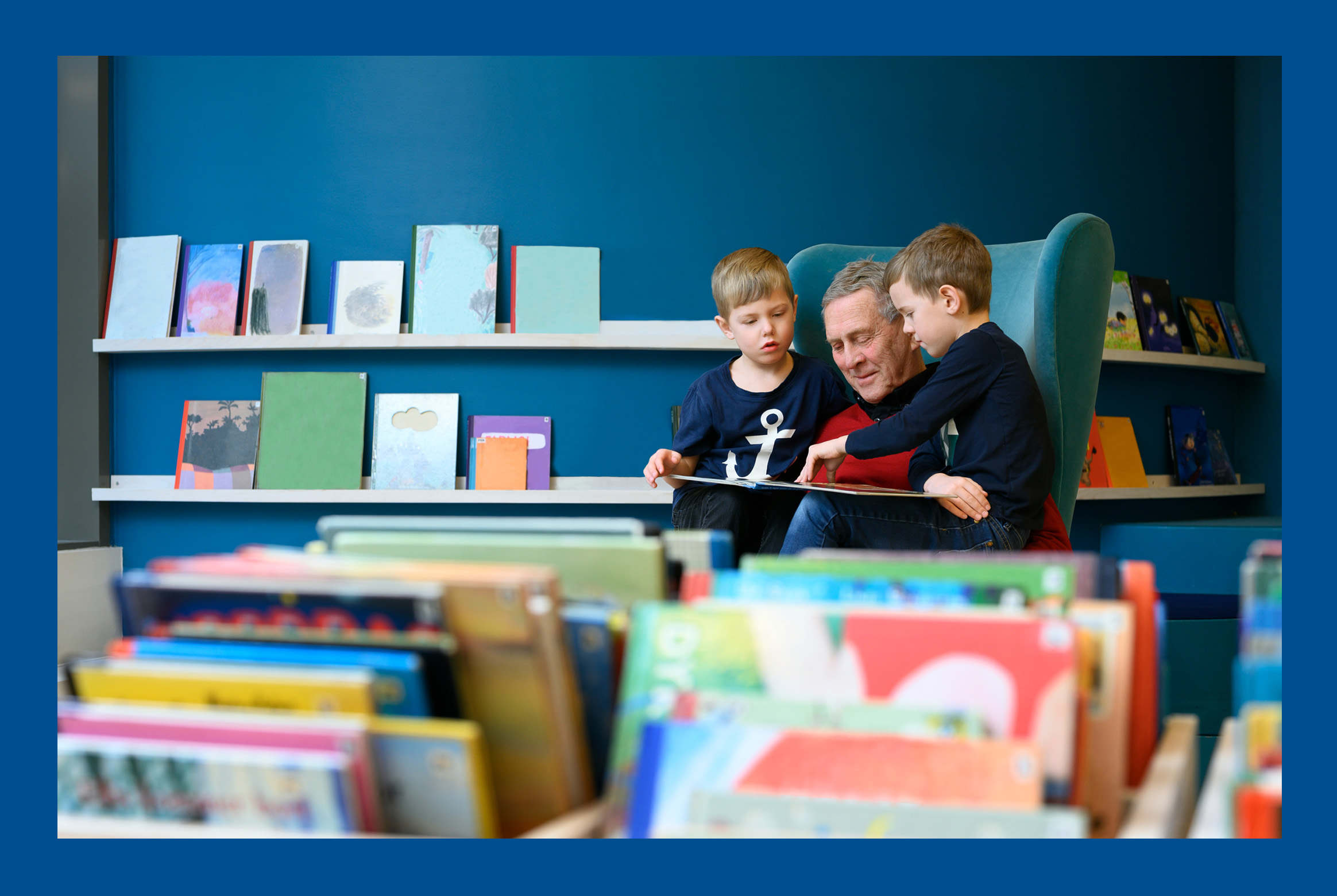 A grandfather reading a book for his grandchildren.